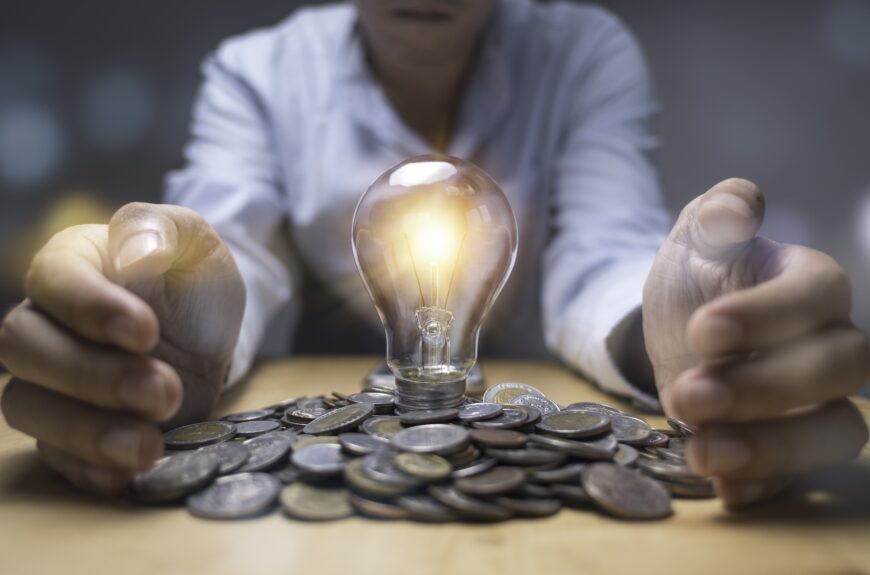 Idea lightbulb on pile of money cradled between two hands