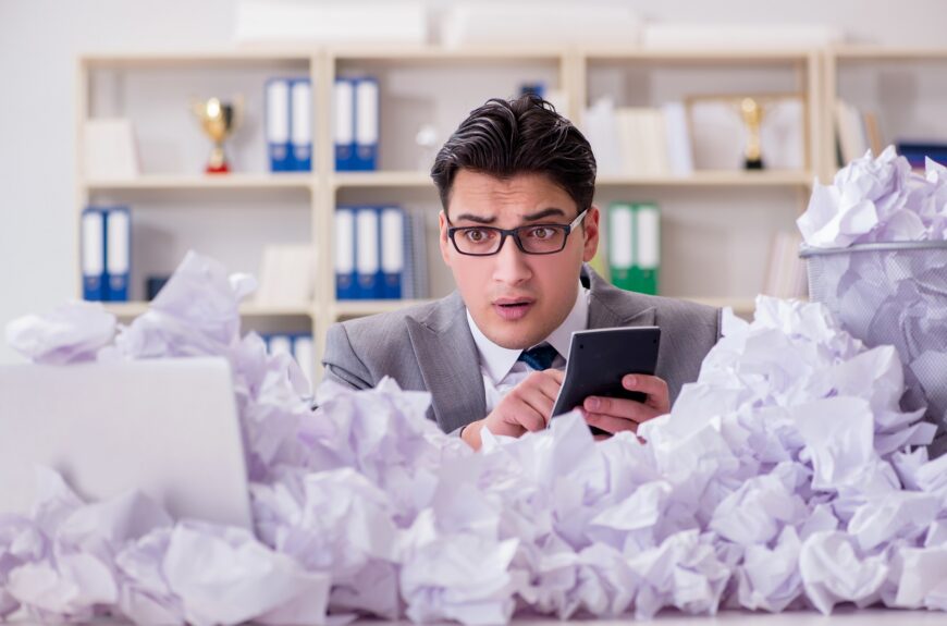 Accountant panicking behind pile of paper